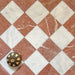Chequerboard layout featuring Fayrouz White 15.2x15.2cm natural marble tiles with a tumbled finish, paired with Rosso marble tiles, installed diagonally and styled with a decorative object for added warmth and contrast.