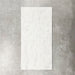 Fayrouz White 30.5x61cm natural marble tiles with a honed finish, featuring soft white tones and subtle grey veining, shown as a single tile sample against a neutral textured backdrop.