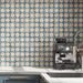 Kitchen featuring Zanzibar Moroccan Arena Blue wall tiles as a striking splashback, showcasing a blue and cream Moroccan style geometric pattern, paired with navy cabinetry, white worktops, brushed brass handles and contemporary stainless steel fixtures.