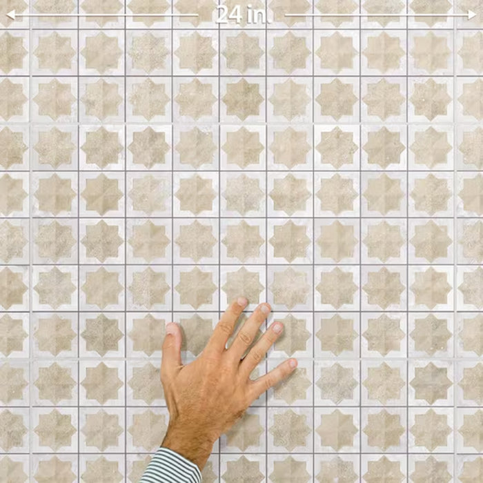 Close-up of Zanzibar Moroccan Natural White ceramic wall tiles in a repeating Moroccan style geometric star pattern, shown with a hand for scale to highlight the 31 x 56cm format, glossy glazed finish and subtle tonal variation.