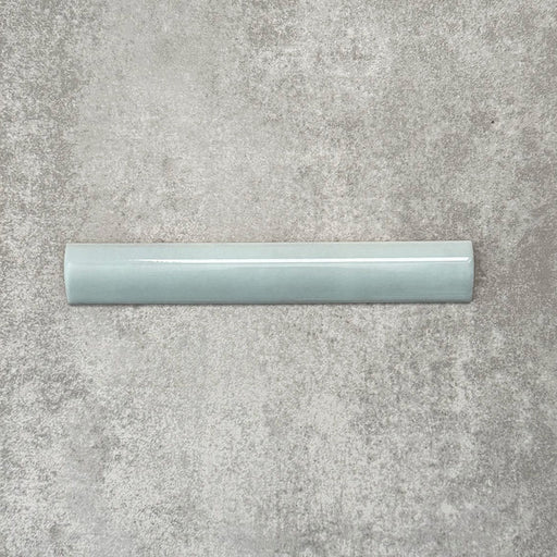 Zellige Aqua 3×20cm Moroccan-style ceramic bullnose tile, showcasing the rounded edge profile, glossy blue-green glaze and subtle tonal variation on a neutral background.