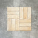 Flat lay of Zellige Arena Marfil Brick 6.5 × 20cm Moroccan-style ceramic tiles, shown in a warm beige and cream colour palette with subtle tonal variation and gently uneven edges, arranged in a basketweave layout on a textured grey background to highlight the handcrafted, zellige-effect finish.