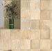 Bathroom wall featuring Zellige Arena Marfil Square 10 × 10cm Moroccan-style ceramic tiles in soft beige and sand tones, installed in a classic grid layout around a freestanding basin and brass tap, with subtle tonal variation and gently uneven edges creating an authentic handcrafted zellige-effect finish.