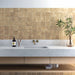 Bathroom splashback featuring Zellige Arena Marfil Square 10 × 10cm Moroccan-style ceramic wall tiles in warm beige tones, laid in a neat grid above a concrete-effect vanity with brass wall-mounted taps, with subtle colour variation and gently uneven edges adding an authentic handcrafted zellige-effect look.