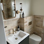 Bathroom featuring Zellige Bone Moroccan-style brick tiles in warm neutral tones, paired with brass fixtures and a compact vanity.