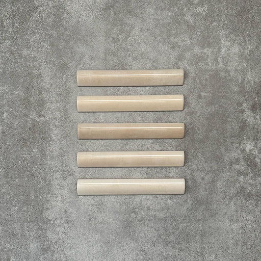 Zellige Bone Moroccan-style bullnose ceramic tiles in a warm beige tone, shown in a neat flat lay arrangement.