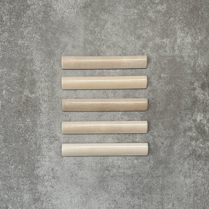 Zellige Bone Moroccan-style bullnose ceramic tiles in a warm beige tone, shown in a neat flat lay arrangement.