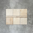 Zellige Bone bullnose ceramic tiles in a soft beige tone, paired with matching square tiles in a flat lay layout.