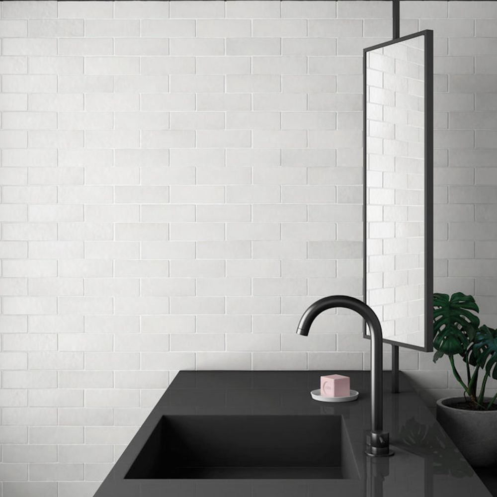 Bathroom wall featuring Zellige Chalk White Moroccan-style brick tiles in a 6.5 × 20cm format, paired with a matte black basin and mirror.