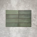 Flat lay of Zellige Malachite Green 6.5×20cm Moroccan-style ceramic brick tiles, showcasing subtle tonal variation, handmade-look texture and rich green glaze on a neutral background.