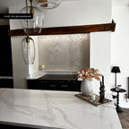 Kitchen featuring Zellige Oyster Brick 6.5x20cm Moroccan-style wall tiles in a herringbone layout, styled with marble worktops, dark wood beams, and black accents for a warm contemporary interior.