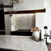 Kitchen featuring Zellige Oyster Brick 6.5x20cm Moroccan-style wall tiles in a herringbone layout, styled with marble worktops, dark wood beams, and black accents for a warm contemporary interior.