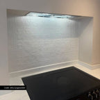 Customer kitchen featuring Zellige Oyster Square Moroccan style porcelain tiles in 10cm x 10cm. Gloss white handmade effect square tiles create a timeless splashback behind a black hob, adding subtle texture and character to a contemporary kitchen design.