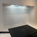 Customer kitchen featuring Zellige Oyster Square Moroccan style porcelain tiles in 10cm x 10cm. Gloss white handmade effect square tiles create a timeless splashback behind a black hob, adding subtle texture and character to a contemporary kitchen design.
