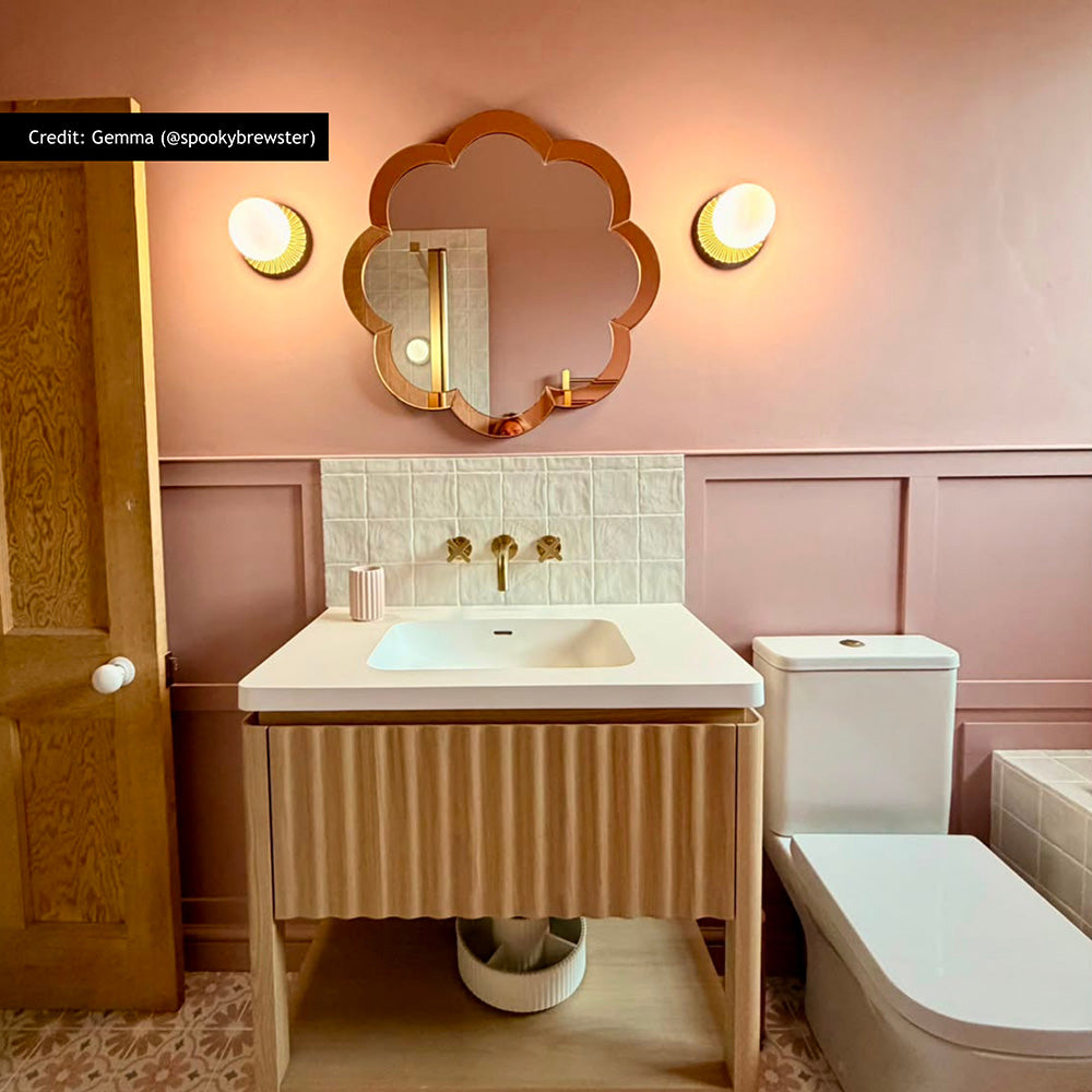 Bathroom featuring Zellige Oyster Square 10cm x 10cm Moroccan style wall tiles around the basin, paired with soft pink panelling, patterned floor tiles, brass details and a scalloped mirror.