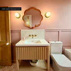 Bathroom featuring Zellige Oyster Square 10cm x 10cm Moroccan style wall tiles around the basin, paired with soft pink panelling, patterned floor tiles, brass details and a scalloped mirror.