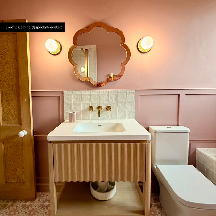 Bathroom featuring Zellige Oyster Square 10cm x 10cm Moroccan style wall tiles around the basin, paired with soft pink panelling, patterned floor tiles, brass details and a scalloped mirror.