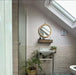 Bathroom featuring Zellige Pink Mist Brick 6.5 × 20cm Moroccan-style ceramic wall tiles in soft pale pink tones, installed in a horizontal brick layout as a half-height wall finish, paired with a wall-mounted basin, chrome fittings and botanical accents for a light, calming zellige-effect look.