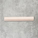 Flat lay of Zellige Pink Mist Bullnose 3 × 20cm Moroccan-style ceramic trim tiles in soft pale pink tones, displayed with a smooth rounded edge and glossy glaze, arranged on a textured grey background to highlight the handcrafted zellige-effect finish and decorative edging profile.