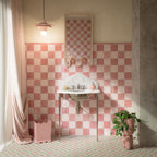 Bathroom featuring Zellige Rose Pink Square 13.2x13.2cm Moroccan-style wall tiles, arranged in a pink chequerboard pattern, paired with colourful patterned floor tiles, a marble washbasin and soft pink accessories.