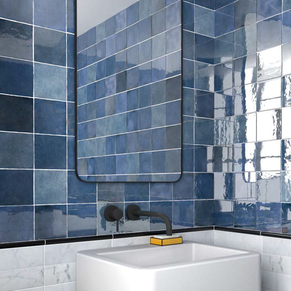 Bathroom featuring Zellige Royal Blue 13.2×13.2cm Moroccan-style ceramic square tiles installed on the walls, showcasing rich blue tones with a glossy handmade-look finish, paired with matte black tapware, a minimalist basin and a contemporary mirror.