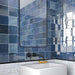 Bathroom featuring Zellige Royal Blue 13.2×13.2cm Moroccan-style ceramic square tiles installed on the walls, showcasing rich blue tones with a glossy handmade-look finish, paired with matte black tapware, a minimalist basin and a contemporary mirror.