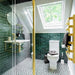 Bathroom featuring Zellige Royal Green Brick 6.5 × 20cm Moroccan-style ceramic wall tiles in rich deep green tones, laid in a horizontal brick layout around a wall-mounted basin, paired with brass fittings, a glass shower screen and patterned floor tiles for a bold, elegant zellige-effect finish.