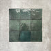 Flat lay of Zellige Royal Green Square 13.2 × 13.2cm Moroccan-style ceramic tiles in rich deep green tones, arranged in a simple grid on a textured grey background, showcasing the glossy glaze, natural tonal variation and handcrafted zellige-effect finish.