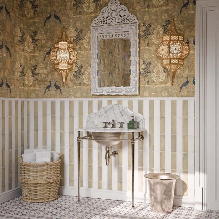 Bathroom featuring Zellige Weald Green Brick 6.5x20cm Moroccan-style wall tiles, arranged vertically in a striped design with white tiles, paired with patterned floor tiles, decorative wallpaper and a marble washbasin.