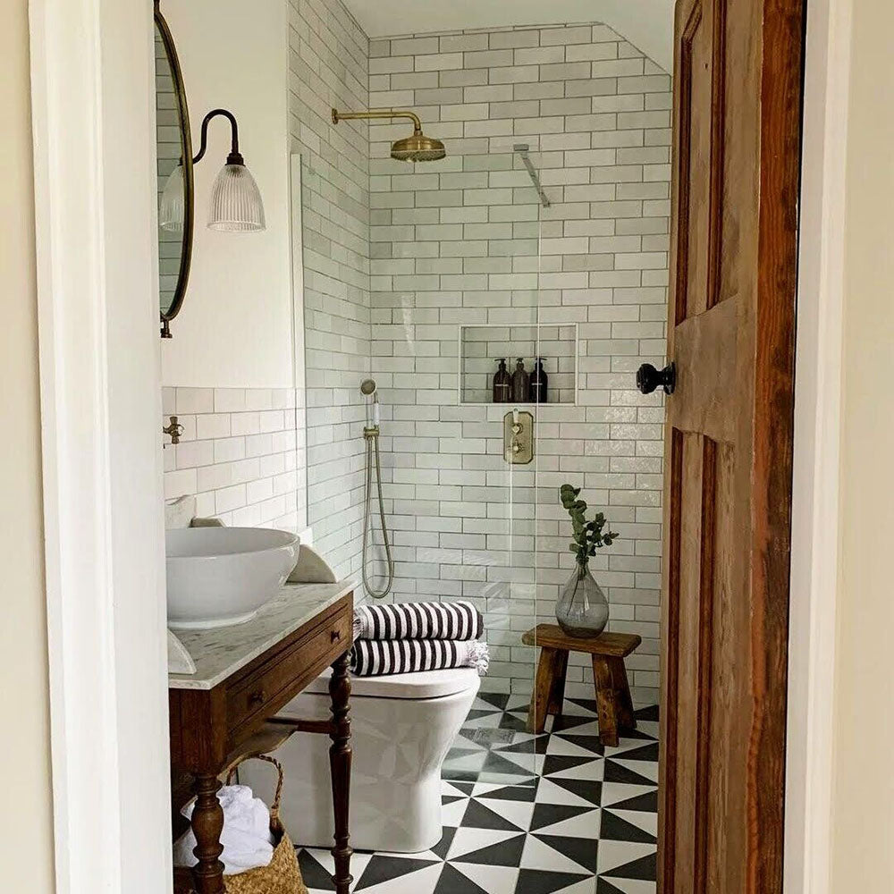 Bathroom featuring Zellige White brick tiles laid horizontally on the walls, paired with patterned floor tiles and brass fittings.