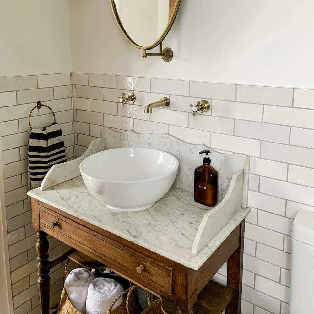 Bathroom featuring Zellige White brick tiles laid horizontally on the walls, paired with patterned floor tiles and brass fittings.