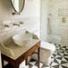 Bathroom featuring Zellige White brick tiles laid horizontally on the walls, paired with patterned floor tiles and brass fittings.