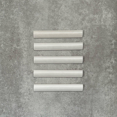 Zellige White bullnose Moroccan-style ceramic tiles in a 3 × 20cm format, shown in a neat row with a smooth, glossy finish.