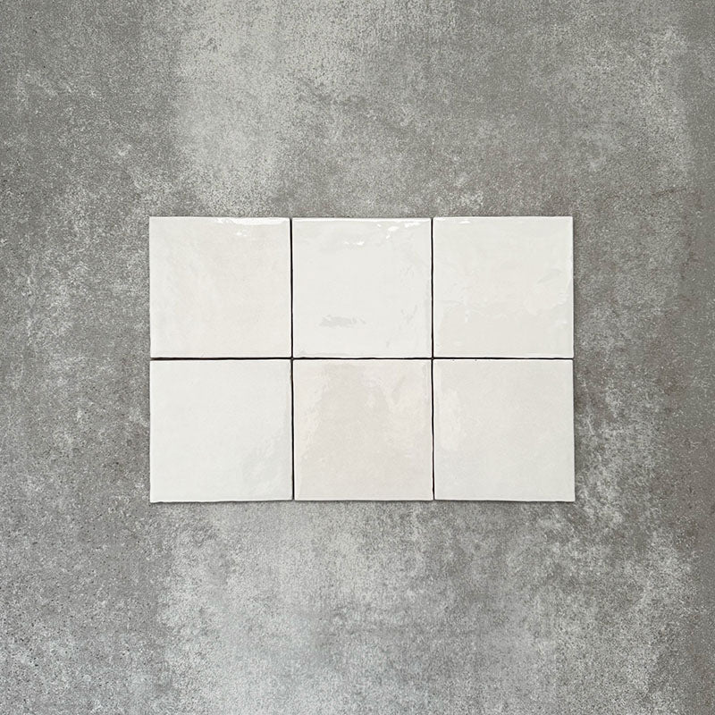 Zellige White square tiles laid in a simple grid, featuring a glossy white finish with subtle tonal variation and softly uneven edges.