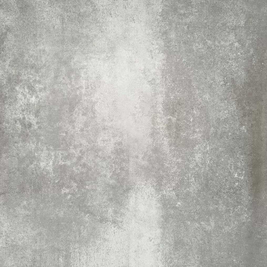 Product display of Pottery Brick Agave Green 5x25cm glossy wall tiles in soft sage and green tones, featuring handcrafted edges and subtle tonal variation against a textured concrete-style backdrop.